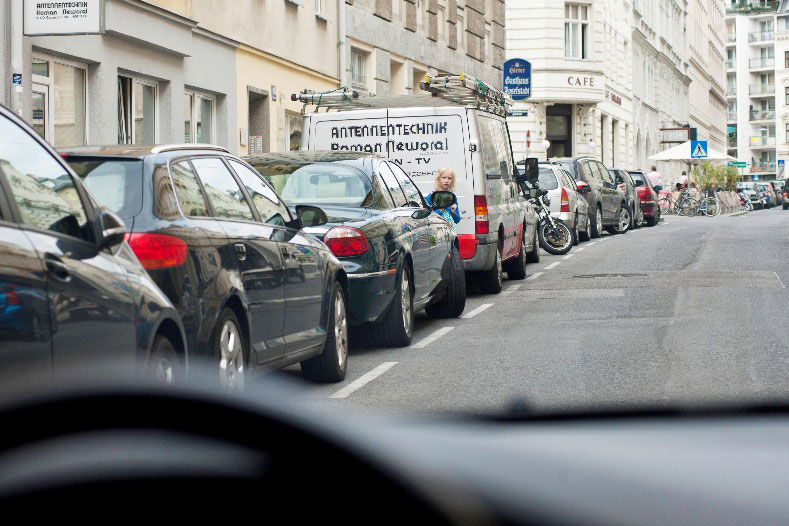 Es kann sich aufgrund der höheren Körpergröße und des dadurch bedingten höheren Blickstandorts bereits einen guten Überblick verschaffen, es kann alle für eine sichere Querungsentscheidung relevanten Verkehrsdetails wahrnehmen. Auch der Autofahrer oder die Autofahrer:in kann das größere Kind einfacher wahrnehmen, sein Kopf ist deutlich über dem Seitenspiegel des parkenden Kfz.