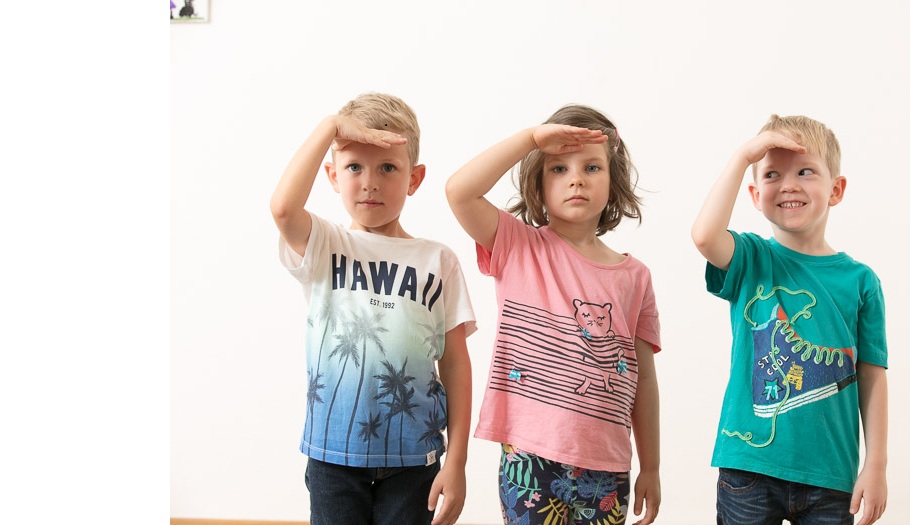 Drei Kinder schauen mit vorgehaltener Hand
