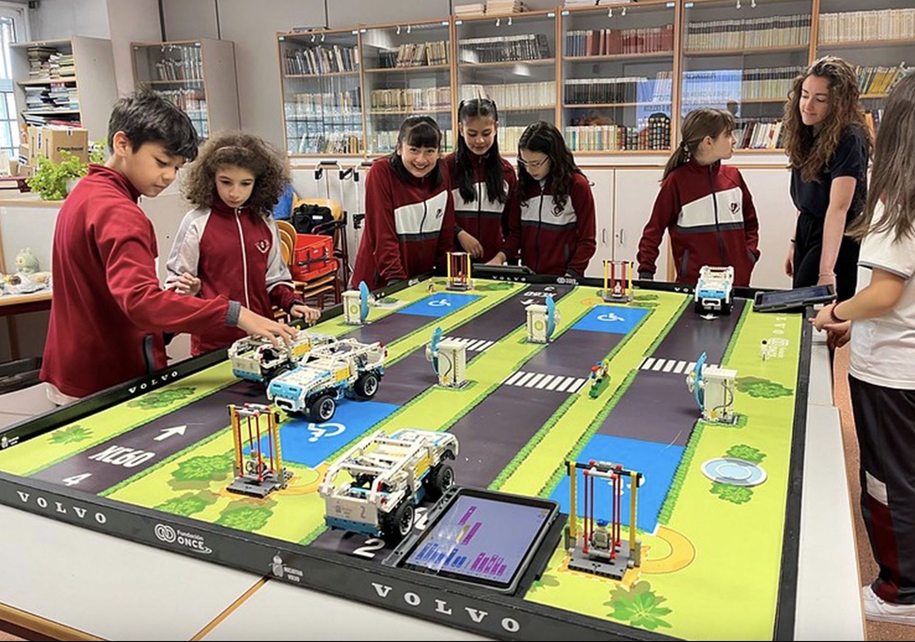 Eine Gruppe junger Teilnehmer:innen der Initiativa Volvo mit ihren selbstprogrammierten Roboter-Fahrzeugen