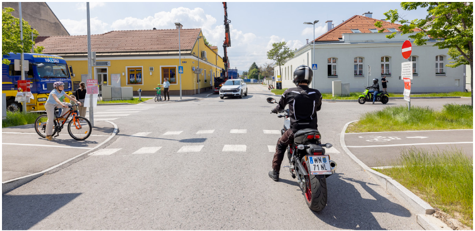 Abbildung 2 zeigt eine Verkehrssituation aus der Perspektive des Motorradfahrers. Der Lkw neben dem radfahrenden Mädchen (links des Motorradfahrers) ist für dieses erst durch einen Schulterblick nach hinten sichtbar.