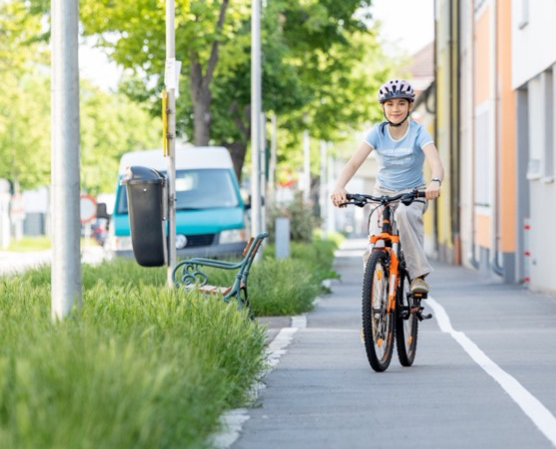 Ein Mädchen fährt mit dem Fahrrad auf einem Fahrradweg