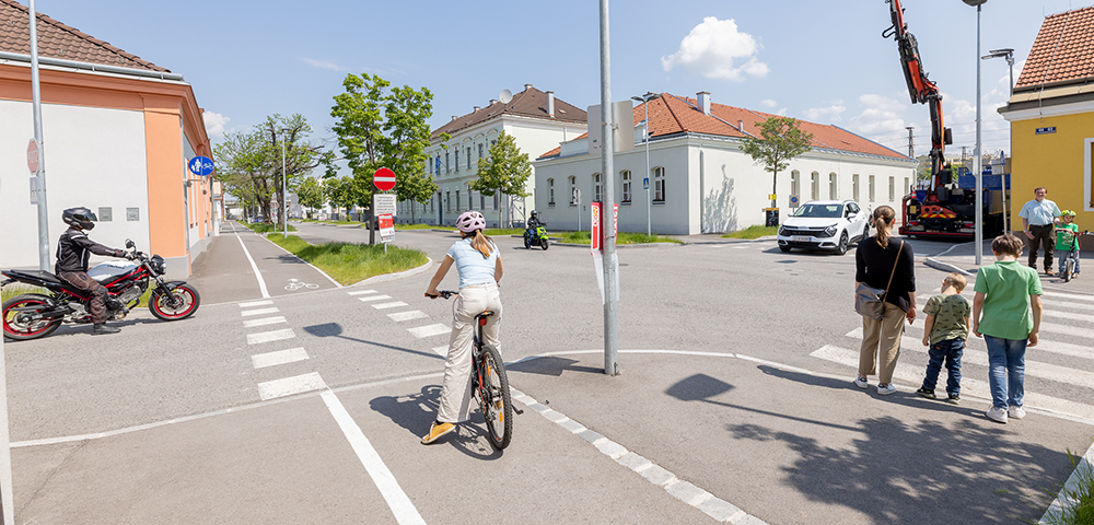 Das Bild der Mobilitäts-App zeigt vergleichend die Perspektive einer erwachsenen Fußgängerin mit einem 6-jährigen und einem 10-jähriges Kindes und einer jungendlichen Radfahrerin an derselben Kreuzung