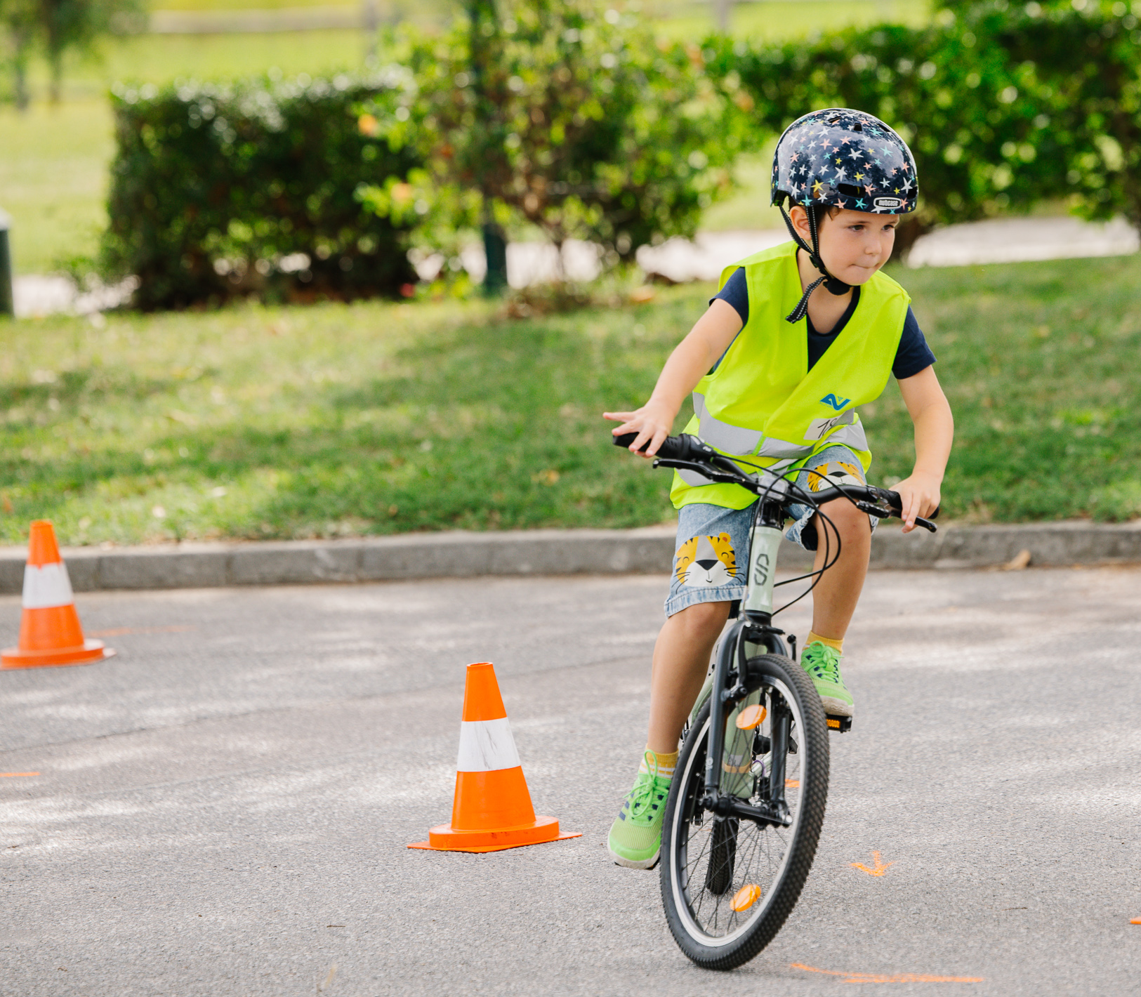 Ein kleiner Junge fährt konzentriert mit seinem Fahrrad durch den Fahrradparcours in Rust (im Rahmen des SARA Projektes) und übt sicheres Verhalten im Straßenverkehr.