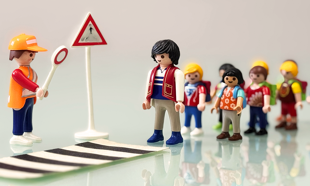 Playmobil Schulkinder stehen an einem Zebtrastreifen