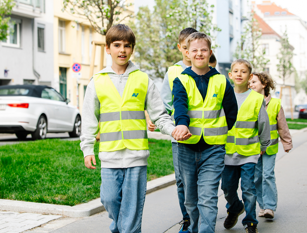 Schulkinder gehen händchenhaltend auf dem Gehweg