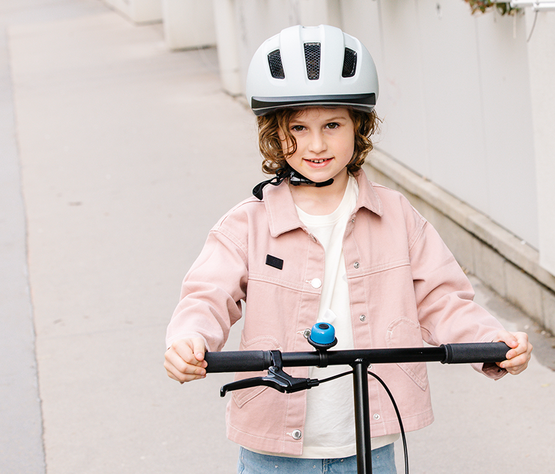 Ein Mädchen fährt mit einem Roller auf dem Gehweg. © Alek Kawka