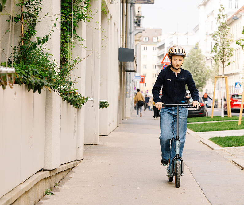 Mädchen fährt mit Roller auf Gehweg © Alek Kawka